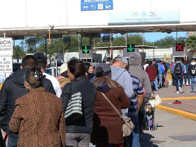 Hundreds of people wait to cross the border bridge from Mexico into Brownsville, Texas. Photo by Rick Jones