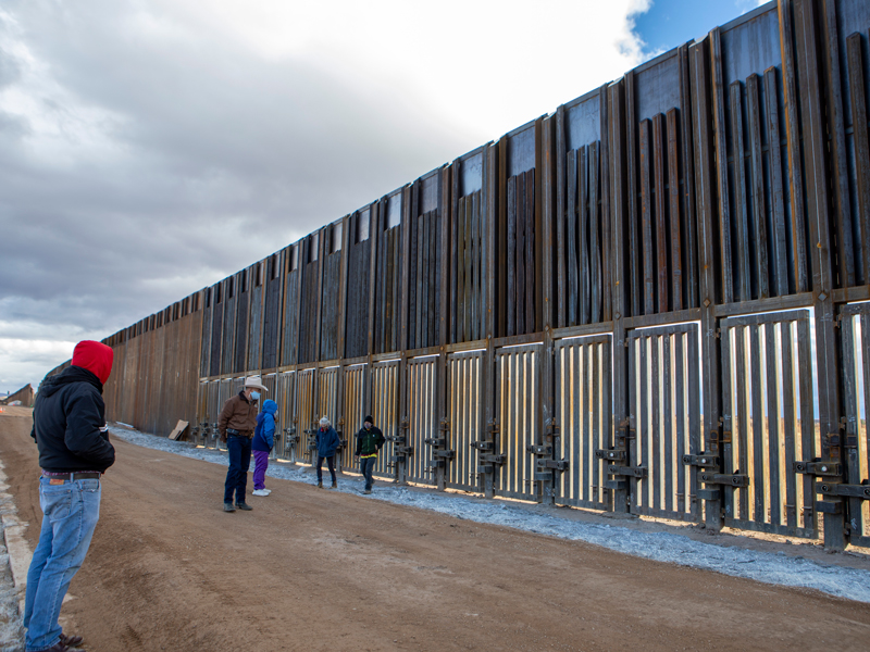 El Rvdo. Mark Adams, con capucha roja, comienza a reunir participantes en la frontera entre Estados Unidos y México. (Foto por Jenea Sánchez)