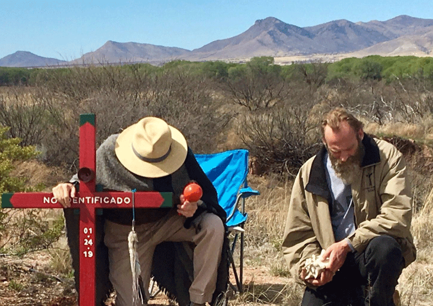El padre Bob Carney dirige la oraci&oacute;n en el sitio fronterizo de la tumba de una persona no identificada. (Foto de cortes&iacute;a)