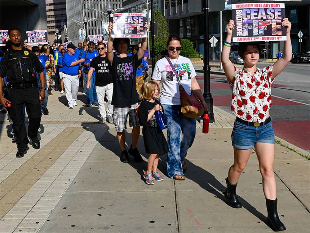 The one hour walk included several prayer stops where shooting victims were remembered. Photo by Rich Copley