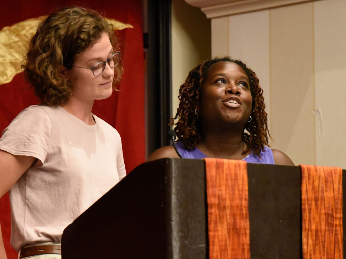 Olivia Thomas (left) and Melva Lowry, who’ve been working at The Center in Baltimore as part of the Hands and Feet Initiative, discuss their work during Thursday’s plenary. (Photo by Rich Copley)