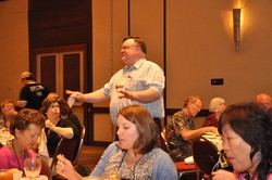 Photo of a man standing among a group of people, speaking