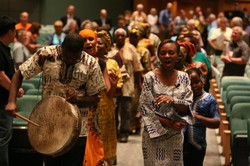 Photo of a group of colorfully-dressed people playing music and singing