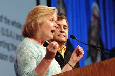 The Rev. Deborah Block, moderator of the All Agency Review Committee and the Rev. Mark Hostetter, monerator of The Way Forward Commission, speak to commissioners Sunday.