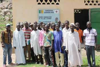 Community members from Gozemey, Cameroon, stand in front of a food granary. 