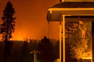 Flames on the hillside pictured with Nekisa Fellowship Hall of the First Presbyterian Church in Kamiah, Idaho, on the right.