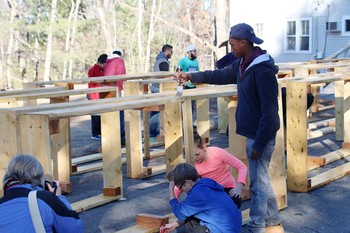 Members of Hartford Street Presbyterian Church, St. James Episcopal Church and Temple Israel in Natick, Mass., along with the Islamic Society of Framingham, apply seal coating to garden beds to be used in the Natick Community Garden, on the grounds of Hartford Street Presbyterian Church.