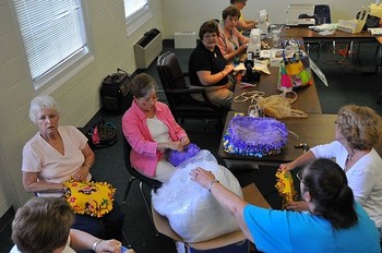 Group members stuff and assemble pillows for children in domestic abuse shelters.