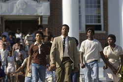 A man walks  with two boys and a woman in front of a crowd from a courthouse.