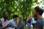 A group of young men speaking to each other outside.