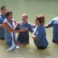 People in water for baptism ceremony