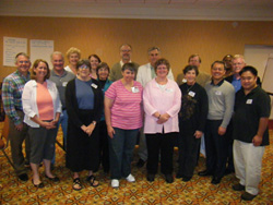 A group of men and women standing together in a hotel lobby.