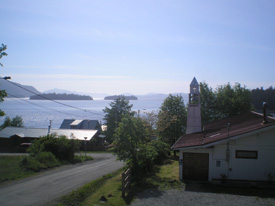 First Presbyterian Church of Craig and Klawock, sitting against a road by the sea and mountains.