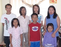 A man and a woman standing with their children.