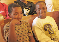 Two children sitting in a church pew.