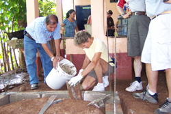 Workers pour dirt into concrete basins.