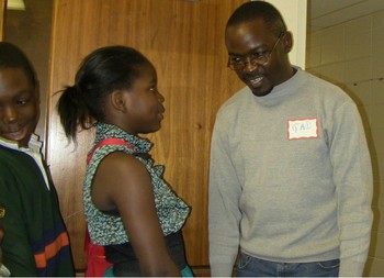 Gad Mpoyo welcoming children at Shalom International Ministry