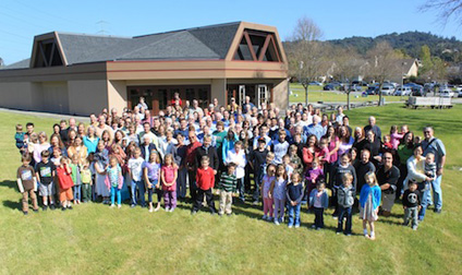 A large group of people standing in front of a church.