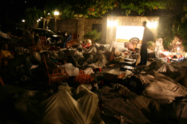 A man standing in a dimly lit makeshift trauma center.