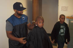 A man cutting a boy's hair