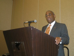 A man speaking at a lectern.