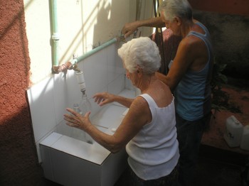 Two volunteers fill bottles with purified water.