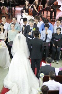 John McCall officiating at wedding of two musicians with other musicians in the background.