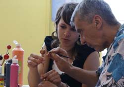 A man and a young woman painting.