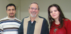 Two  men and a woman standing and smiling