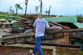 A man carrying debris from wreckage.