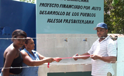 Three people at a ribbon-cutting ceremony.