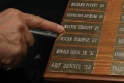 John Holst points to Walter Soboleff’s name on a plaque honoring the SJC basketball hall of fame. Soboleff, who graduated in 1928, became a legendary Tlingit elder before his death last year at 102.