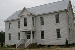 A large white school building on a field.