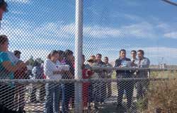 People at a fence in the desert