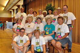 A group of peple in white shirts posing for a photo.