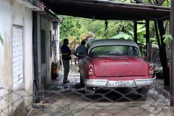 Before worship at the Presbyterian Mission at Manati, some men engage in a little car talk.