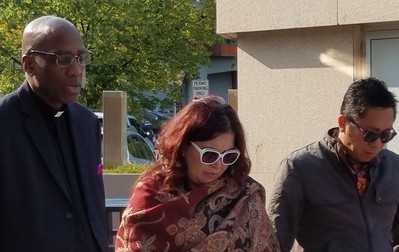 J. Herbert Nelson prays with Sam Wondal and his wife before they enter the Norris Cotton Federal Building in Manchester, NH, for their regular meeting with ICE. Wondal was told to return in a few weeks to fly to Indonesia.