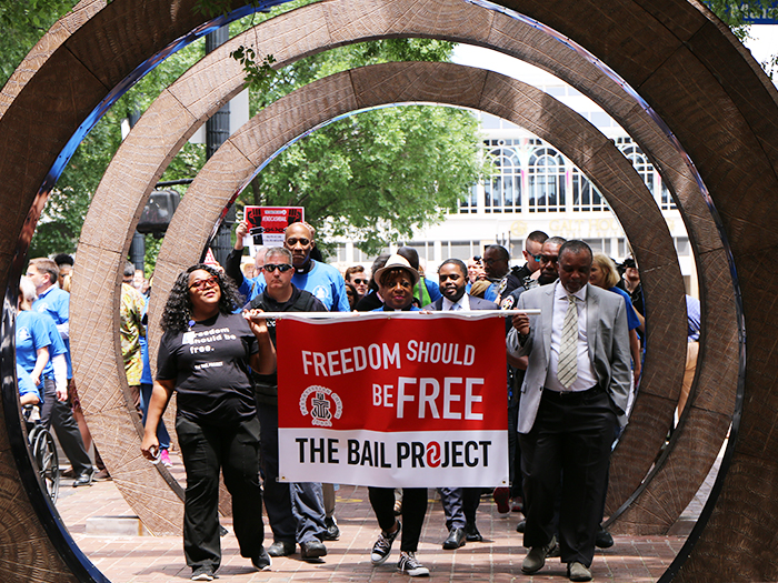 Marchers emerge through public art in downtown Louisville. (Photo by Angie Stevens)