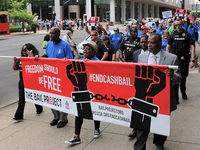 More than 250 people marched behind, left to right, Shameka Parrish-Wright of The Bail Project; the Rev. Dr. J. Herbert Nelson, II; the Rev. Dr. Diane Moffett; and J. Phillip Thompson, deputy mayor of New York City. (Photo by Tammy Warren)