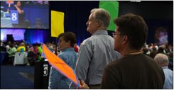 GA attendees line up at a microphone during plenary. 