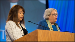 Frances Lin (left) and Amy Fowler deliver the report of the Middle East Issues Committee.