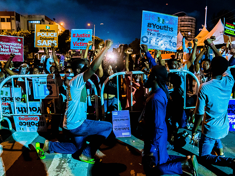 Late at night after being addressed by the Lagos State Chief of Staff, all protesters decided to take a knee as the National Anthem was played. Photo by Toby James Candids | Wikimedia Commons