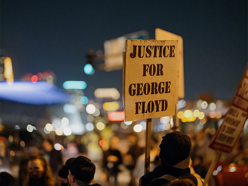 A protester holds a sign stating