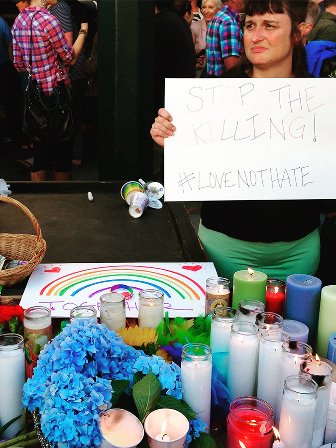 A table of candles and prayers at a vigil held in Portland, Oregon to commemorate the victims of the terrorist attack in Orlando's Pulse club in June 2016. Photo by Sarah Mirk.